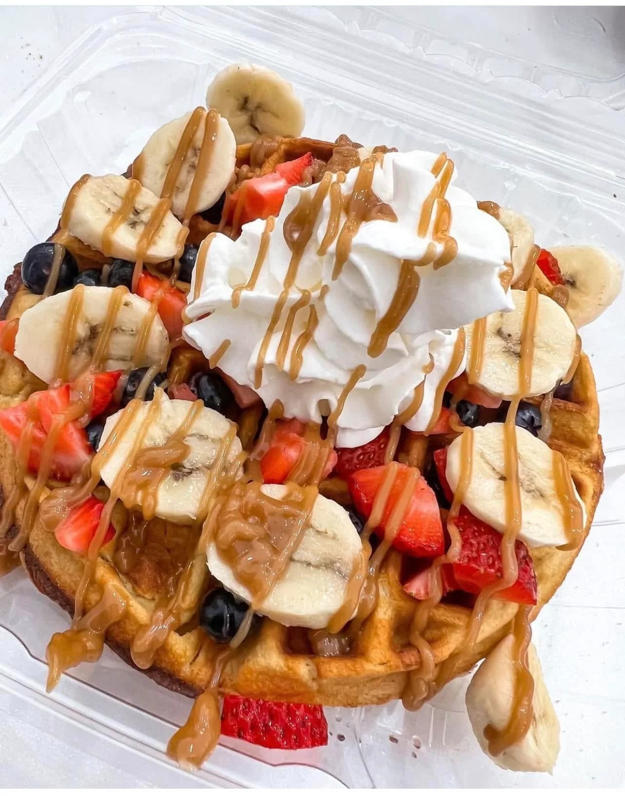 Protein waffles with banana, strawberries, blueberries, and peanut butter